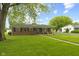 Charming brick home featuring well maintained yard with mature trees and sidewalk at 30 N Depot St, New Palestine, IN 46163