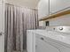 Well-lit laundry area featuring a modern washer and dryer with white cabinets at 30 N Depot St, New Palestine, IN 46163