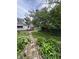 Landscaped backyard featuring a brick path, green grass, and mature trees at 303 Walnut St, Greenfield, IN 46140