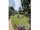 Large backyard with a brick pathway, outbuilding, pond, and various plants and trees at 303 Walnut St, Greenfield, IN 46140