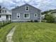 The back exterior of the home shows gray siding, white trim, and a well-maintained lawn at 3636 Crescent Ave, Indianapolis, IN 46208