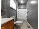 This bathroom includes a tub, toilet, sink with a wooden vanity, and gray walls at 3636 Crescent Ave, Indianapolis, IN 46208
