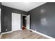 Cozy bedroom with gray walls, light hardwood floors, and a door at 3636 Crescent Ave, Indianapolis, IN 46208