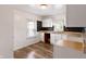 Bright kitchen with white cabinets, dark tile backsplash, and light-colored wood flooring at 3636 Crescent Ave, Indianapolis, IN 46208