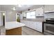 Well-lit kitchen with white cabinetry, stainless steel stove, and a window over the sink at 3636 Crescent Ave, Indianapolis, IN 46208