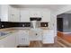 Well-lit kitchen featuring white cabinets, stainless steel appliances, and dark tile backsplash at 3636 Crescent Ave, Indianapolis, IN 46208