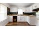 A kitchen featuring white cabinets, dark backsplash, wood floors, and a double bowl stainless steel sink at 3636 Crescent Ave, Indianapolis, IN 46208