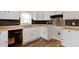A kitchen featuring white cabinets, dark backsplash, wood floors, and stainless steel range hood at 3636 Crescent Ave, Indianapolis, IN 46208