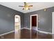 Open living room with hardwood floors, ceiling fan, and an arched doorway to the kitchen at 3636 Crescent Ave, Indianapolis, IN 46208