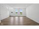 Bright living room featuring hardwood floors, white walls, large windows, and an entrance door at 3931 Wren Dr, Brownsburg, IN 46112