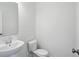 Powder room with white pedestal sink and toilet against a white wall at 3931 Wren Dr, Brownsburg, IN 46112