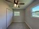 Bright bedroom with neutral walls, ceiling fan, and double windows overlooking the yard at 409 Parkway St, Whiteland, IN 46184