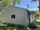 The side of this cozy home is nicely sided, surrounded by lush greenery, and features a white framed window at 409 Parkway St, Whiteland, IN 46184