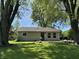 Beautiful front yard with mature trees, a lush green lawn, and a charming single-story home, providing great shade at 409 Parkway St, Whiteland, IN 46184