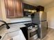 This updated kitchen is equipped with stainless steel appliances, dark cabinets, and light countertops at 409 Parkway St, Whiteland, IN 46184