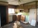 Outdated kitchen featuring wood cabinets, a sink under the window, and an adjacent doorway at 409 Parkway St, Whiteland, IN 46184