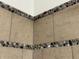 Close up of the shower with earth toned tile and a stone detail at 409 Parkway St, Whiteland, IN 46184