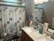 Detailed bathroom with seashell themed shower curtain, and double sinks on a granite counter at 4920 E Daisy Ln, Mooresville, IN 46158
