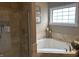 Spa-like bathroom featuring a large tub, walk-in shower, and neutral stone accents at 4920 E Daisy Ln, Mooresville, IN 46158