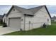 Attached two-car garage with white brick exterior, providing secure parking and storage at 4920 E Daisy Ln, Mooresville, IN 46158