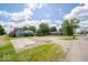 Two-story home with light blue siding, next to a parking area, set amongst green trees under a blue sky at 5 E Jefferson St, Maxwell, IN 46154