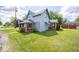 Charming two-story home with a covered porch, red brick, and a well-maintained lawn on a bright day at 5 E Jefferson St, Maxwell, IN 46154