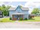 Charming two-story home with a covered front porch and a well-maintained lawn on a sunny day at 5 E Jefferson St, Maxwell, IN 46154