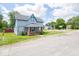 Charming two-story home with covered porch, blue siding, and well-kept lawn on a bright day at 5 E Jefferson St, Maxwell, IN 46154