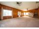Expansive living room with wood paneling, ceiling fans, and large windows offering ample natural light at 5 E Jefferson St, Maxwell, IN 46154