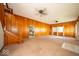 Open-concept living room featuring wood-paneled walls, ceiling fans, and staircase leading to upstairs at 5 E Jefferson St, Maxwell, IN 46154