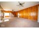 Spacious living room with wood paneling, ceiling fans, carpet flooring, and staircase to second floor at 5 E Jefferson St, Maxwell, IN 46154