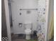 The bathroom features a standard toilet, a colorful shower curtain, and white walls at 513 Andover Rd, Anderson, IN 46013