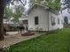 Exterior of home and backyard with gravel patio, fire pit, and green grass at 513 Andover Rd, Anderson, IN 46013