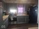 Well-lit kitchen showcasing gray cabinetry, a stainless steel range, and a contrasting black refrigerator at 513 Andover Rd, Anderson, IN 46013