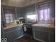 Functional kitchen featuring gray cabinets, wood countertops, and a stainless steel gas range at 513 Andover Rd, Anderson, IN 46013