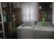 A functional laundry room equipped with a washer and dryer, and upper shelving for storage at 513 Andover Rd, Anderson, IN 46013