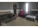 Cozy living room with plush seating, neutral carpet, and a glimpse into the adjacent kitchen area at 513 Andover Rd, Anderson, IN 46013