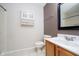 This bathroom features a vanity, toilet, and wall cabinet, with a well-lit mirror providing a modern touch at 5240 Ochs Ave, Indianapolis, IN 46254