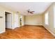 A spacious living room with hardwood floors, a ceiling fan, multiple windows, and access to a bathroom at 5240 Ochs Ave, Indianapolis, IN 46254