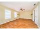 An expansive living room featuring wood floors, a ceiling fan, shelving, and plenty of natural light from the windows at 5240 Ochs Ave, Indianapolis, IN 46254