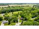 Wide aerial perspective featuring a home nestled among trees, bordered by fields, providing a private, pastoral setting at 5253 W 8Th Street Rd, Anderson, IN 46011