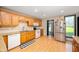 Well-lit kitchen featuring wooden cabinets, a window view, and modern appliances at 5253 W 8Th Street Rd, Anderson, IN 46011