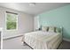 Charming bedroom featuring a soft green accent wall, cozy bedding, and a large window at 5264 Veranda Dr, Noblesville, IN 46062