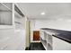 Basement bar area features black and white flooring and white cabinetry for storage and serving at 5349 Culver St, Indianapolis, IN 46226