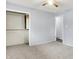 A spacious carpeted bedroom with gray walls and ceiling fan showcases a closet and door at 5349 Culver St, Indianapolis, IN 46226