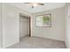 Neutrally decorated carpeted bedroom showcasing a closet and a window with bright natural light at 5349 Culver St, Indianapolis, IN 46226