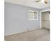 A carpeted bedroom with gray walls and a ceiling fan is naturally lit by a window at 5349 Culver St, Indianapolis, IN 46226