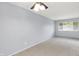 Comfortable bedroom with plush carpeting, a ceiling fan, and a large window for natural light at 5349 Culver St, Indianapolis, IN 46226
