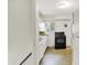 Functional kitchen with white cabinets, black appliances, and a window overlooking the backyard at 5349 Culver St, Indianapolis, IN 46226