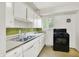 Traditional kitchen featuring white cabinetry, neutral countertops, and a black oven range at 5349 Culver St, Indianapolis, IN 46226